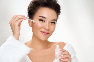 a woman applying serum for uneven skin tone